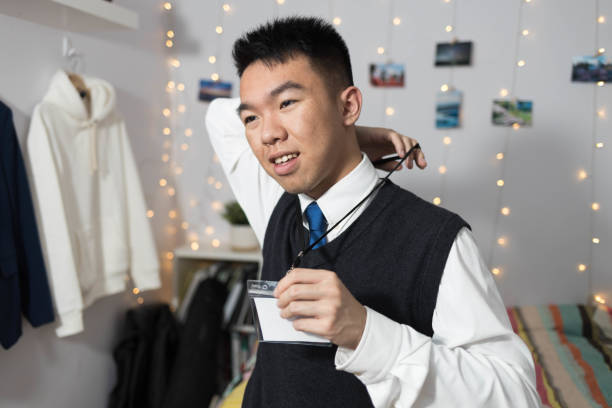 istock A young man putting a name tag around his neck 2177033515