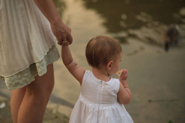 Calm waters and a mother's gentle hold create a peaceful scene, ducks in the backdrop. It illustrates the growing movement towards eco-conscious parenting