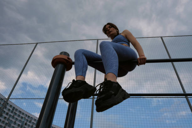 istock woman in blue sportswear performs a pull-up exercise on an outdoor bar against a cloudy sky. This image highlights her strength and determination in maintaining upper body fitness. 2177045156