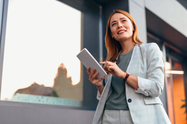 istock Businesswoman Using Tablet In Front Of The Office Building 2177045470