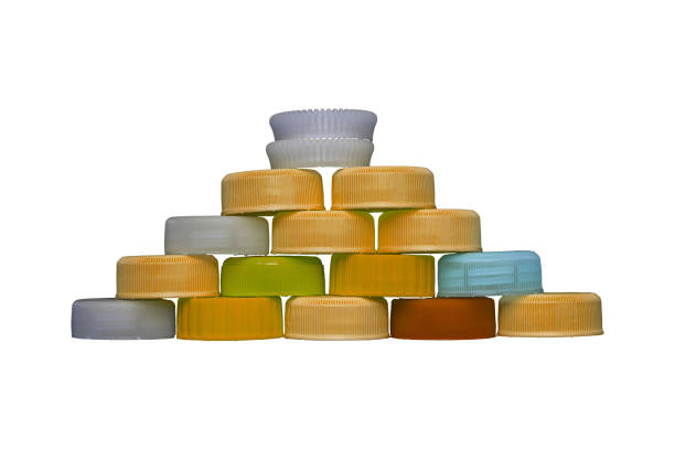 Orange plastic HDPE caps pyramide from drinking water bottles isolated.