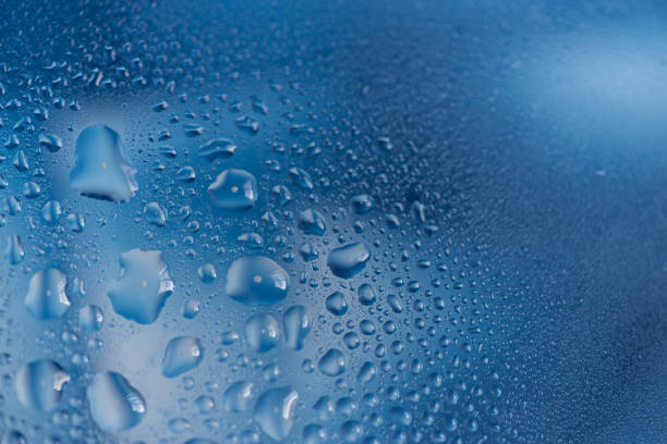 Water droplets on glass with blue background