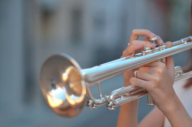 istock A person is holding a silver trumpet and playing it 2177051964