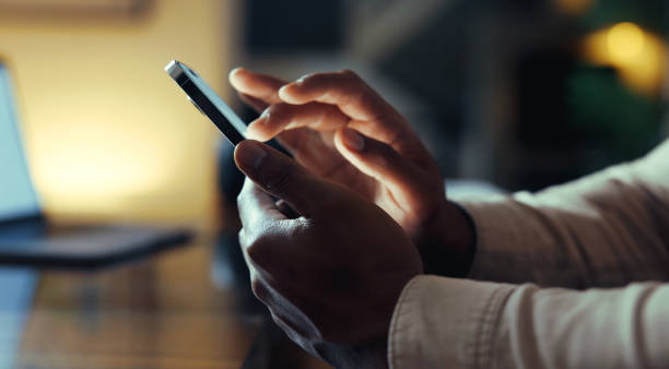 istock Businessman's Hands Texting on Mobile Phone Late at Night 2177052442