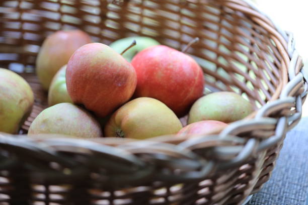 istock A basket filled with fresh apples sits atop a wooden table, perfect for snacking or decorating 2177054786