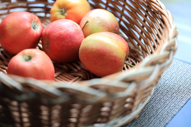 A basket filled with fresh apples placed on a table.