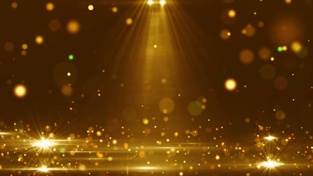 istock Glittering golden background with glowing light beams, sparkling bokeh particles, celebration or new year festival design. 2177054958