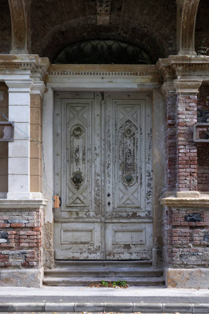Selective focus of huge old door made of wood and metal in brick wall of building