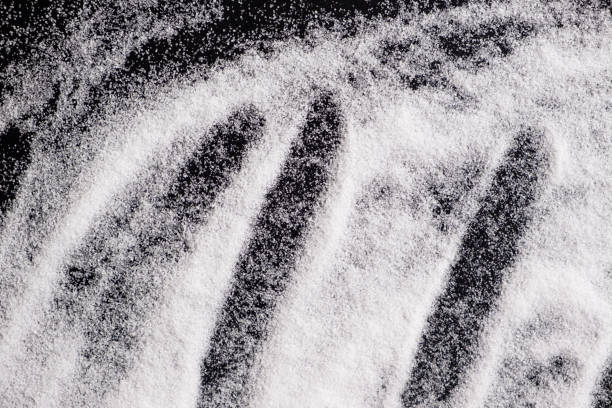istock Finely ground stone white rock salt texture on black background, top view. 2177059269