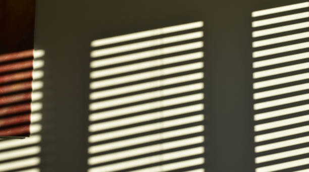 istock Stripes of light from window blind on a wall. Atmospheric abstract interior design 2177061072