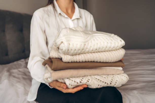 istock Woman Holding Folded Knit Sweaters in Hands 2177066028