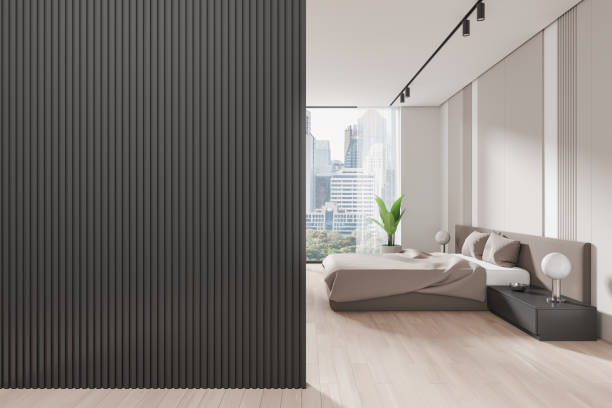 Modern home bedroom interior bed and nightstand, plant on hardwood floor. Cozy sleep room with panoramic window on Bangkok skyscrapers. Copy space empty wall panels. 3D rendering
