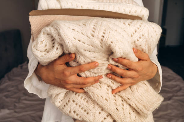 istock Woman Holding Folded Knit Sweaters in Hands 2177066494