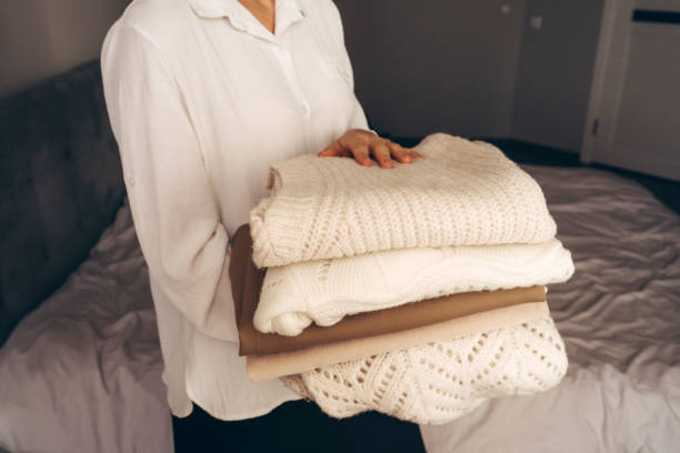 istock Woman Holding Folded Knit Sweaters in Hands 2177066503