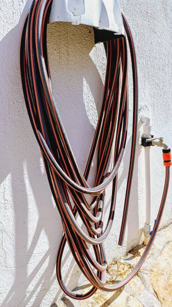 istock garden hose hanging on the wall. 2177067739