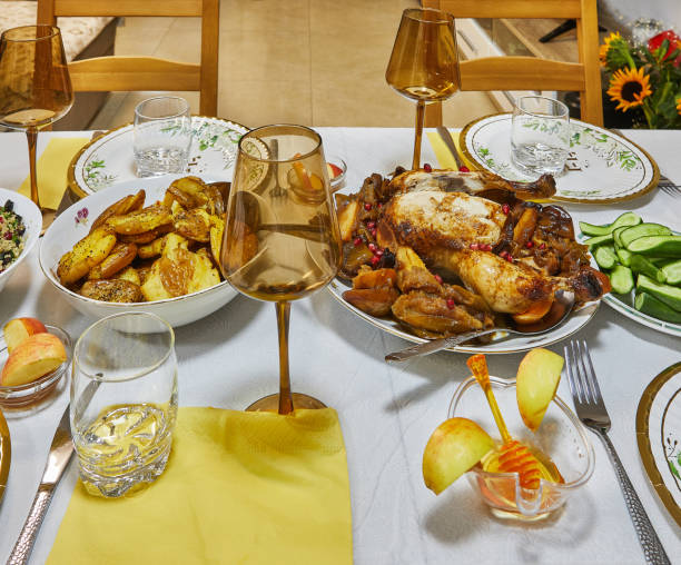 istock A golden roasted chicken garnished with pomegranate seeds, presented elegantly on a dining table with glasses and side dishes 2177068600