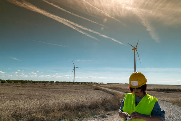 istock Wind turbine inspector reviewing documents at a wind farm under clear skies 2177068778