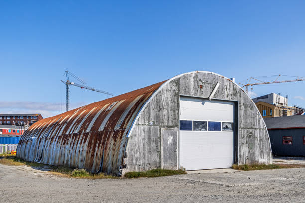 Nuuk, Godthåb, Greenland, Denmark - August 19th 2024:  Small industry building constructed as a Nissen hut with eroded corrugated iron and a concrete facade
