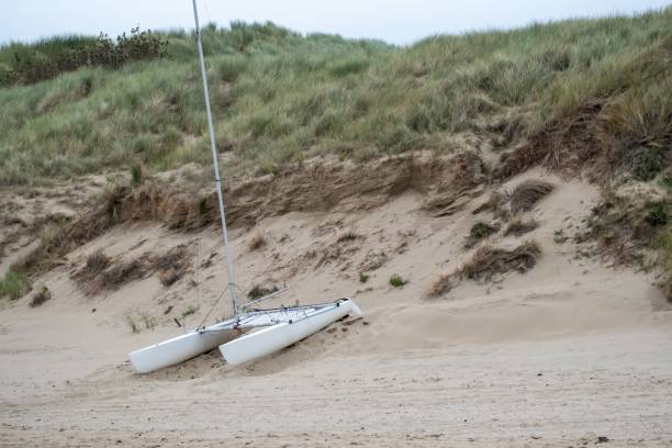Sailboat catamaran in front of the dunes