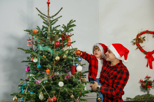 istock Dad and son joyfully decorating their Christmas tree together 2177087687
