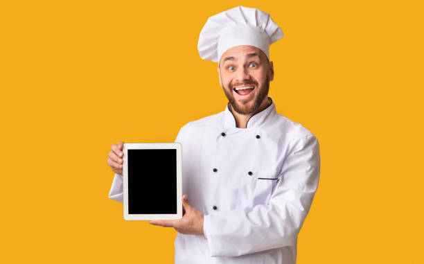 istock Chef Holding Digital Tablet Showing Blank Screen Standing, Yellow Background 2177089427