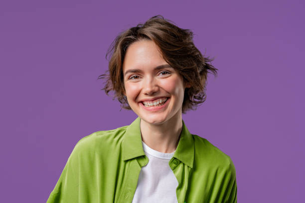 istock Young charming woman looking to camera and smiling on violet background. Face. 2177089627