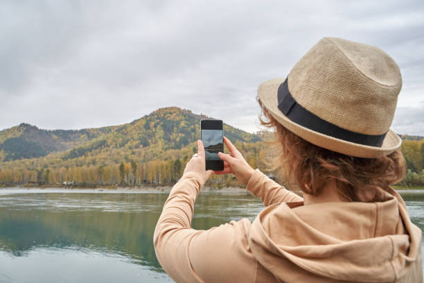 istock Traveler captures scenic mountain view with smartphone while wearing hat 2177089754