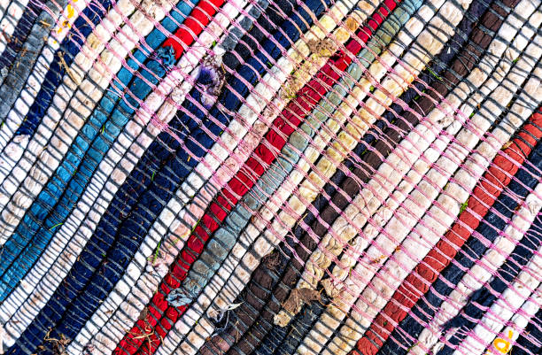 istock Old homespun doormat made from strips of cloth as background 2177090132