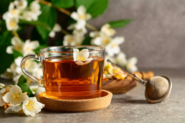 istock Cup of jasmine tea and fresh jasmine flowers on a stone table. 2177090312