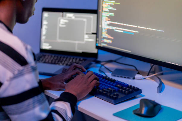 istock Close-up of African American programmer's hands typing on a laptop keyboard, writing code in a late-night home office. Focus on coding, big data, and cloud computing security, working on encryption, data communication, and network servers. 2177091650