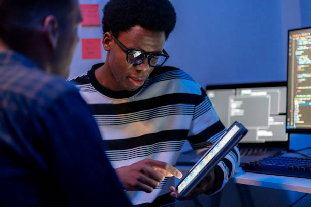 A multiracial software engineer leads a discussion on software development and testing processes in a modern tech business office. Using a digital tablet to display data, the engineer explains strategies to enhance the functionality, reliability, and security of applications. Teamwork, and problem-solving, showcasing modern software development practices un ingeniero de software multirracial dirige una discusión sobre el desarrollo de software y los procesos de prueba en una oficina de negocios de tecnología moderna. utilizando una tableta digital para mostrar datos, el ingeniero explica estrategias para