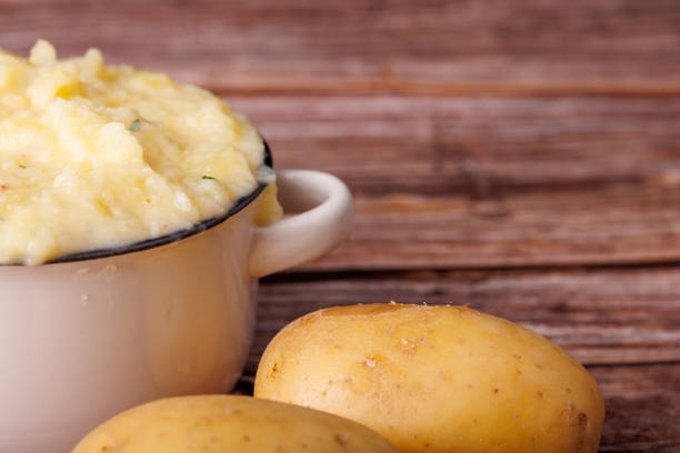 istock Creamy Mashed Potatoes in a Bowl with Fresh Potatoes on a Rustic Wooden Table 2177098945