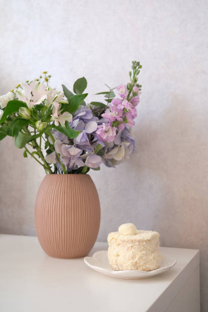 An Elegant Floral Arrangement Complemented by a Beautiful Cake on a Table Setting