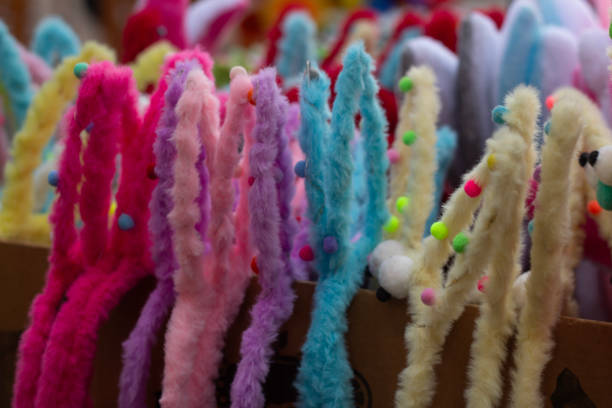 Horizontal photo. Counter with souvenirs. Shop selling carnival costumes, colorful soft fur pink, blue, yellow rabbit ears for Easter holiday. Festival Tbilisoba. City street fair. Tbilisi. Georgia