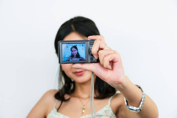 Young Asian Female Model with a Camera Taking Selfie Pictures