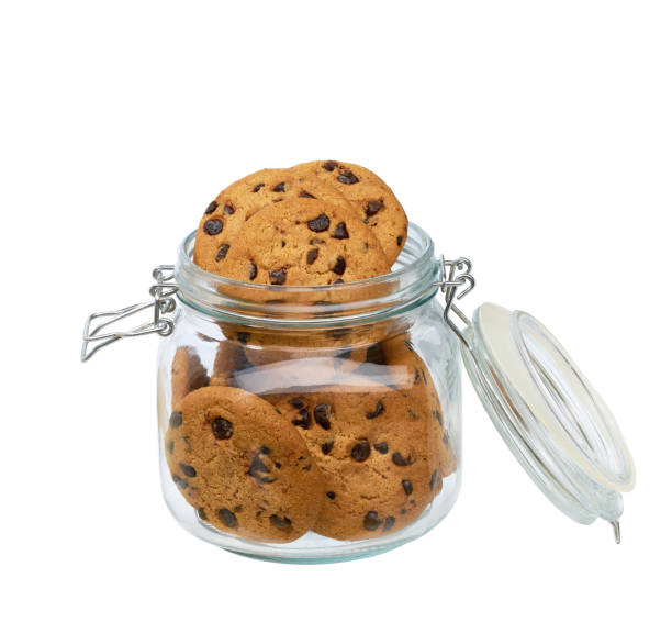 A glass storage or canning jar filled with chocolate chip cookies isolated on black with reflection, with lid open.