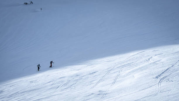 istock Two skiers slowly ascending on snowy mountain slope during winter 2177108737