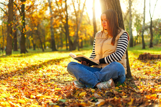 istock Woman reading a book outdoors in autumn 2177111106