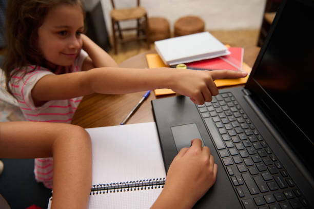 istock Children learning together using a laptop at a wooden table 2177112574