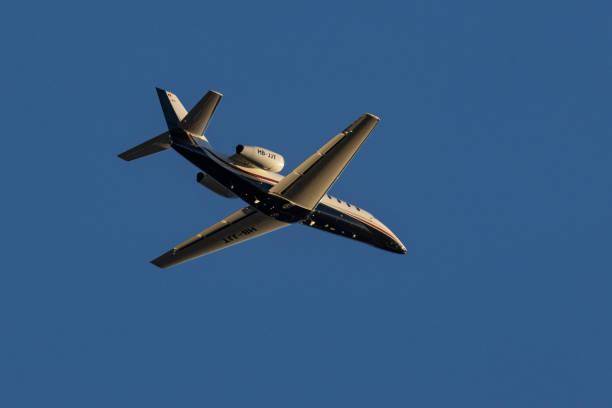 Airplane flying in the distance in the sky above Frankfurt am Main, people in foreground defocused
