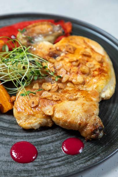 Delicious roasted chicken breast with garlic and herbs on plate