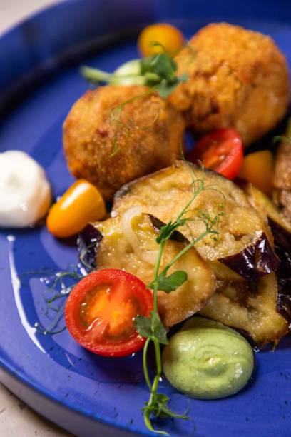 istock Arancini being served on blue plate with eggplant and tomatoes 2177124220
