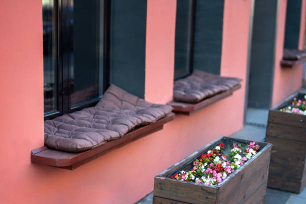 cozy street restaurant features a unique design with pillow-filled window benches instead of traditional seating, inviting guests to relax and enjoy casual dining amidst the urban ambiance