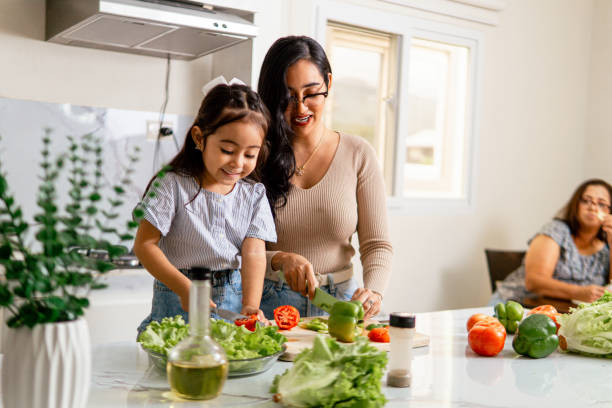 istock Hispanic Mother and Daughter Smiling While Cooking Together in the Kitchen 2177127991