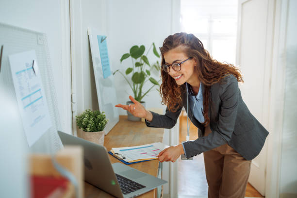 istock Young beautiful woman having video call while using laptop at modern office 2177130968