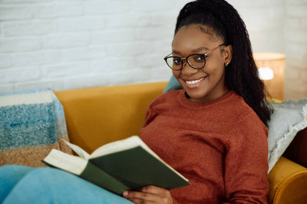 istock Happy black woman reading book and looking at camera. 2177132773