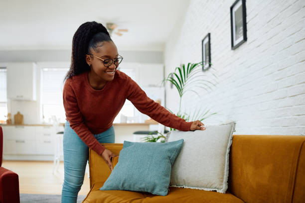 istock Happy black woman decorating her sofa with pillows. 2177132945