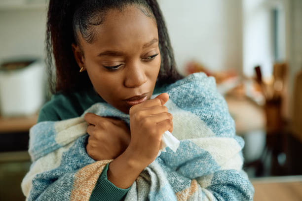 istock Ill black woman coughing while being wrapped in a blanket. 2177133338