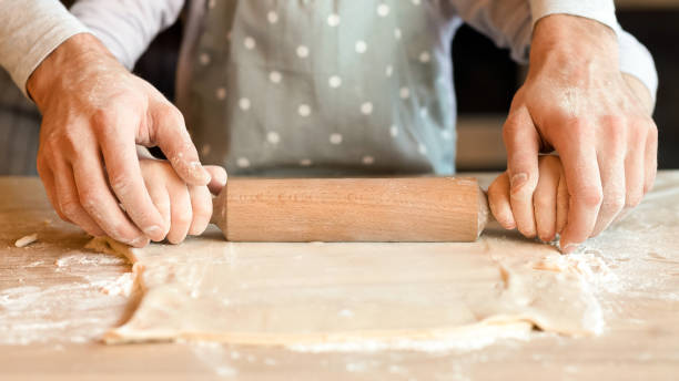 istock Unrecognizable Man And Little Daughter Rolling Pastry Dough Together, Closeup 2177137710