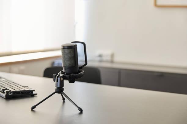 istock Professional microphone is standing on a desk in a bright home office, ready for recording a podcast or a voice over 2177138274